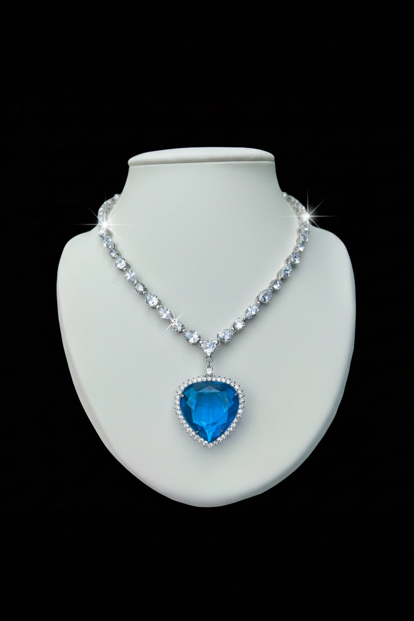 Necklace with a blue heart pendant on a mannequin bust against a black background.