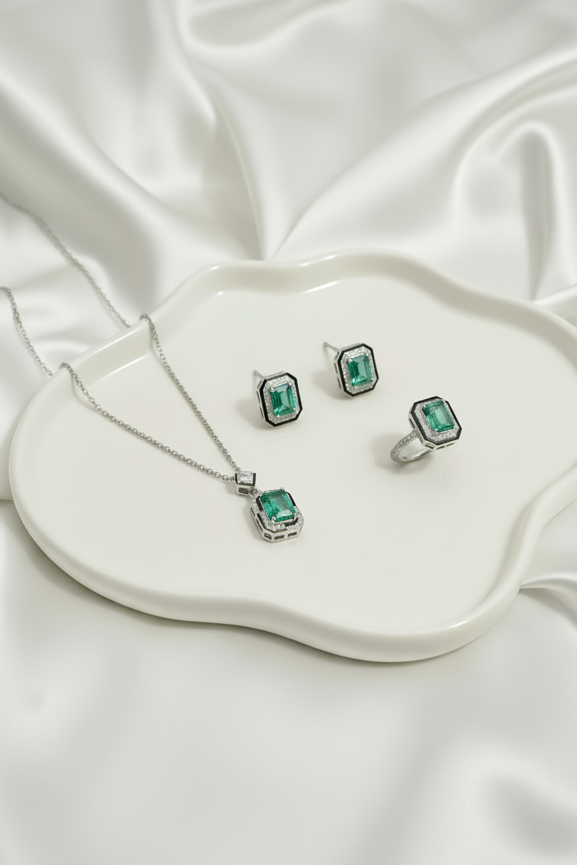 Emerald jewelry set in a green jewelry box on a beige surface