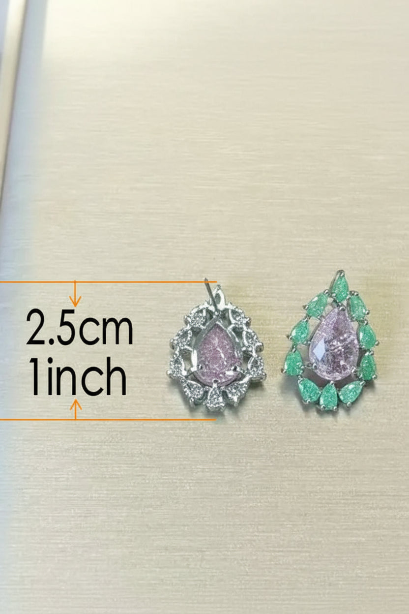 Pair of earrings with green gemstones and measurements on a beige background